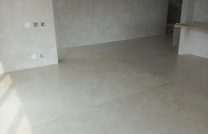 Grey micro screed flooring and wall finish in open-plan room