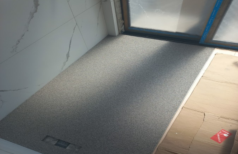 Quartz carpet shower floor installation next to marble tiles